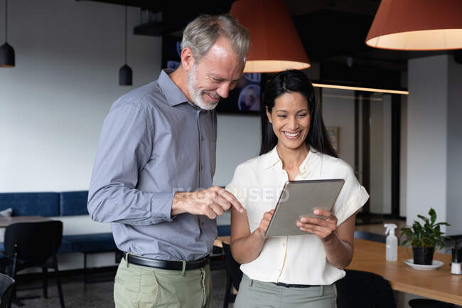 Diversi uomini d'affari in piedi utilizzando tablet digitale in ufficio moderno. affari ufficio moderno tecnologia sul posto di lavoro. — Foto stock