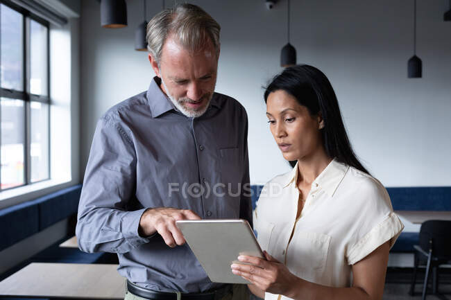 Diverse business people standing using digital tablet in modern office. business modern office workplace technology. — Stock Photo