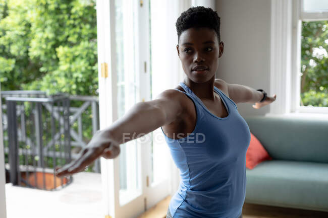 Afroamerikanerin bei Dehnübungen zu Hause. Zu Hause bleiben in Selbstisolierung in Quarantäne — Stockfoto