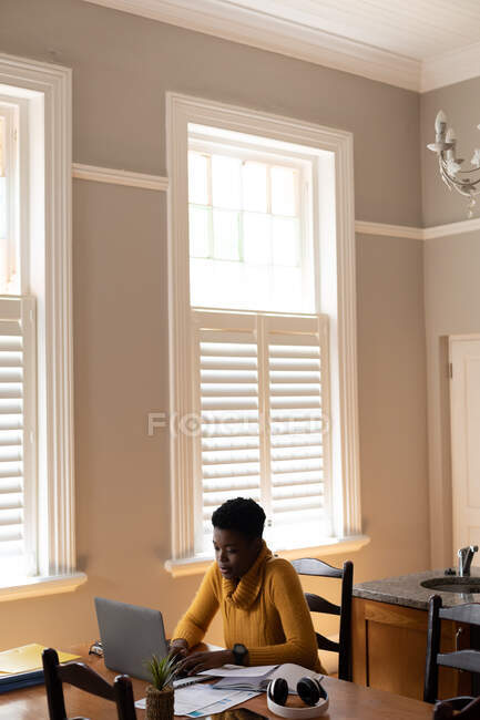 Африканська американка використовує ноутбук на кухні. Перебуваючи вдома в ізоляції під час карантину.. — стокове фото
