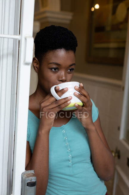 Donna afroamericana che beve caffè a casa. stare a casa in isolamento personale in quarantena — Foto stock