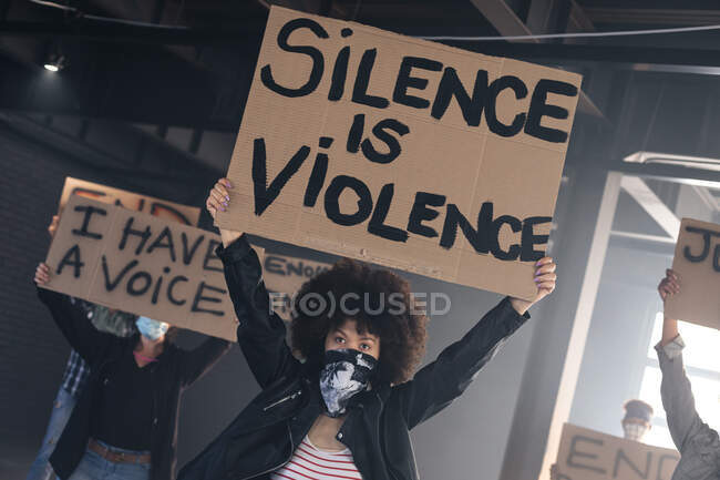 Multi grupo étnico de pessoas usando máscaras faciais segurando sinais de protesto. gênero fluido lgbt identidade conceito de igualdade racial. — Fotografia de Stock