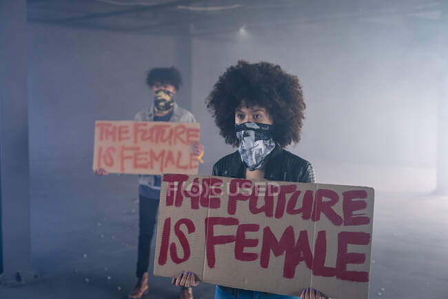 Mann und Frau mit Gesichtsmasken tragen Protestschilder. Geschlecht fluid lgbt Identität rassische Gleichberechtigung Konzept. — Stockfoto