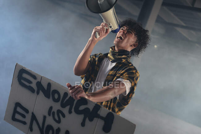 Mixed race man holding protest sign shouting in megaphone. gender fluid lgbt identity racial equality concept. — Stock Photo