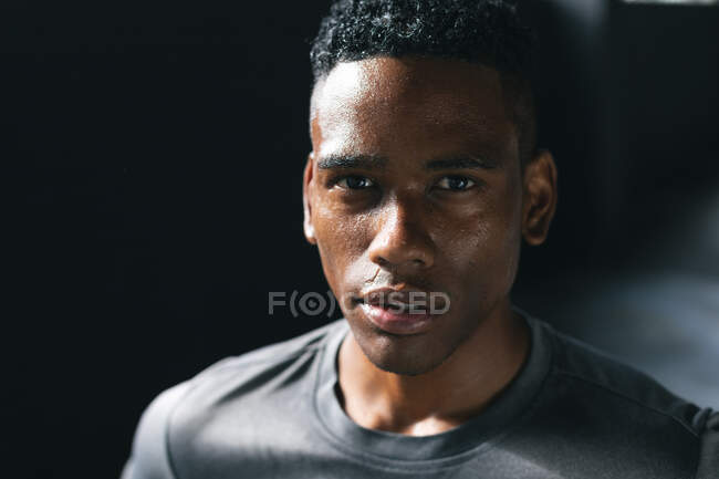 Portrait of african american man standing in an empty urban building looking at camera. urban fitness healthy lifestyle. — Stock Photo