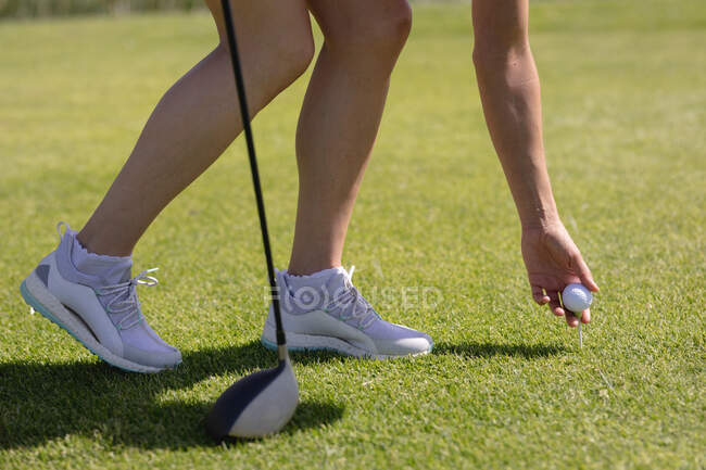 Niedriger Abschnitt der Frau, die Golf spielt, lehnt sich an den Ball, bevor sie einen Schuss abgibt. Sport Freizeit Hobbys Golf gesunder Lebensstil im Freien. — Stockfoto