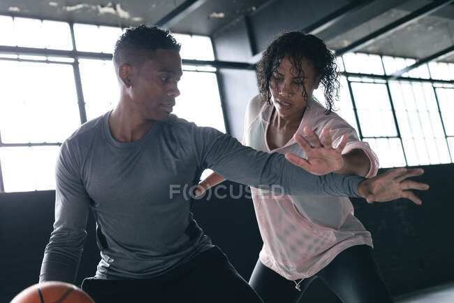Uomini e donne afroamericani in piedi in un edificio urbano vuoto a giocare a basket. fitness urbano stile di vita sano. — Foto stock