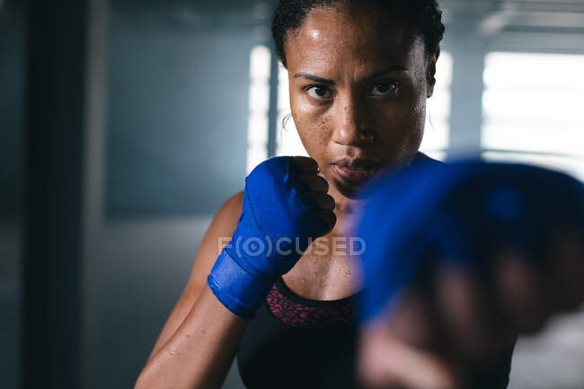 African american woman throwing punches in the air in an empty urban building. urban fitness healthy lifestyle. — Stock Photo