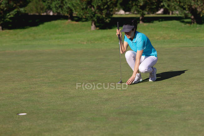 Kaukasische Frau, die Golf spielt und Ball platziert, bevor sie auf Loch schießt. Sport Freizeit Hobbys Golf gesunder Lebensstil im Freien. — Stockfoto