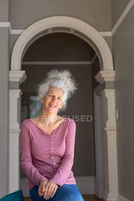 Portrait of senior caucasian woman looking at camera and smiling. staying at home in self isolation during quarantine lockdown. — Stock Photo