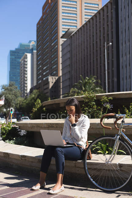 Africano americano mulher usando laptop enquanto sentado no parque corporativo. estilo de vida conceito de vida durante coronavírus covid 19 pandemia. — Fotografia de Stock
