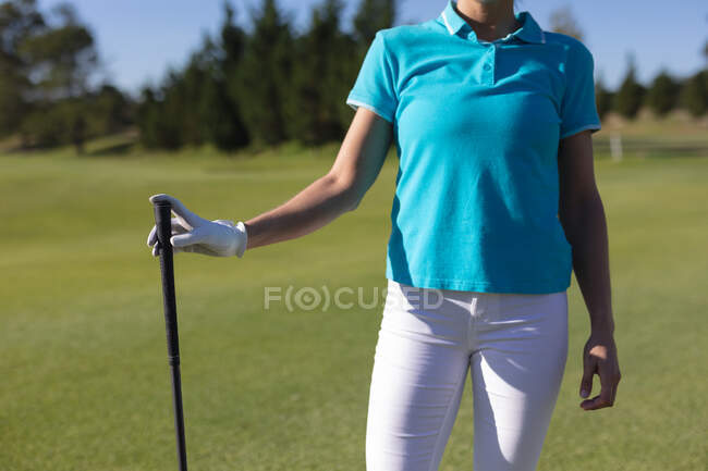 Midsection of woman standing on golf course holding golf club. sport leisure hobbies golf healthy outdoor lifestyle. — Stock Photo
