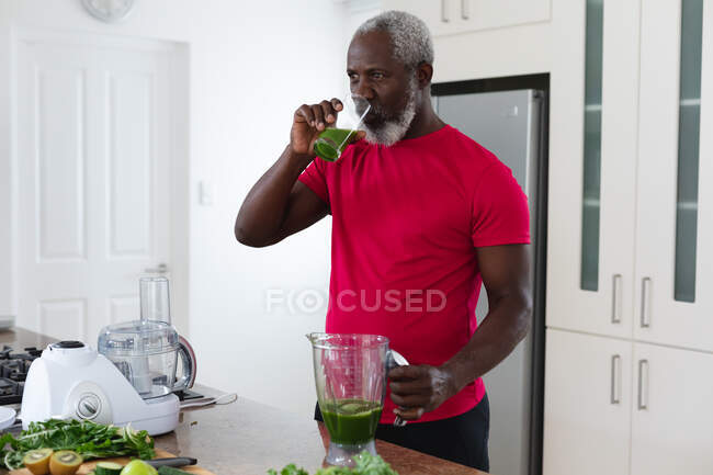 Senior afrikanisch-amerikanischer Mann trinkt Obst und Gemüse Gesundheitsgetränk. Gesundheit Fitness Wohlbefinden im Altenheim. — Stockfoto