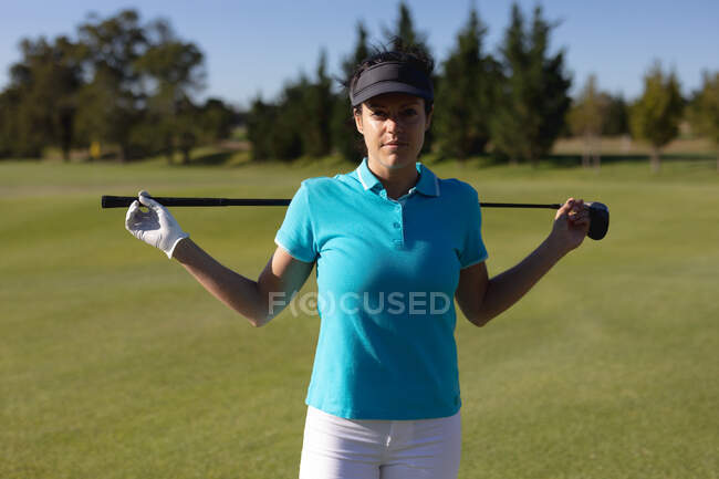 Porträt einer kaukasischen Frau auf dem Golfplatz, die den Golfschläger über die Schultern hält. Sport Freizeit Hobbys Golf gesunder Lebensstil im Freien. — Stockfoto