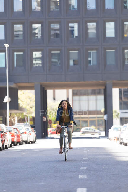 Uma afro-americana a andar de bicicleta na rua. estilo de vida que vive durante o coronavírus covid 19 pandemia. — Fotografia de Stock