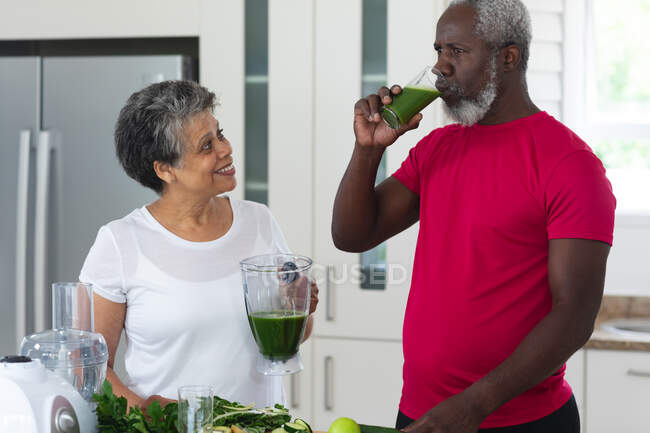 Uomo e donna afroamericani anziani che bevono bevande salutari a base di frutta e verdura. salute fitness benessere a casa di cura senior. — Foto stock