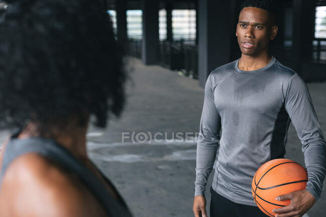 Homem e mulher afro-americanos num edifício urbano vazio e a falar. fitness urbano estilo de vida saudável. — Fotografia de Stock