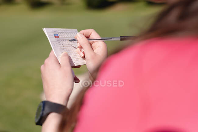 Sobre vista ombro de mulher jogando golfe preenchendo scorecard. esporte lazer hobbies golfe saudável ao ar livre estilo de vida. — Fotografia de Stock