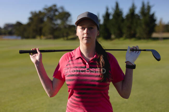 Retrato de mulher caucasiana no campo de golfe segurando taco de golfe através dos ombros. esporte lazer hobbies golfe saudável ao ar livre estilo de vida. — Fotografia de Stock