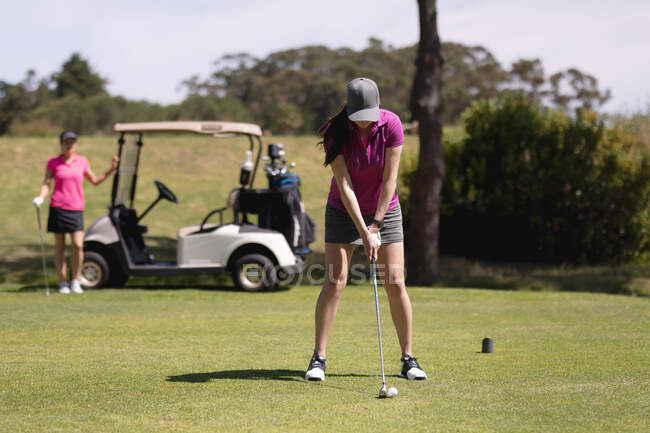 Белая женщина занимается гольфом на поле для гольфа в яркий солнечный день. спорт и активный образ жизни. — стоковое фото