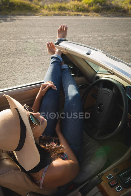Жінка приймає придорожню перерву в машині в сонячний день. Літня дорога на заміській дорозі — стокове фото