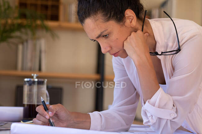 Caucasian woman concentrating, writing, working from home. Staying at home in self isolation during quarantine lockdown. — Stock Photo