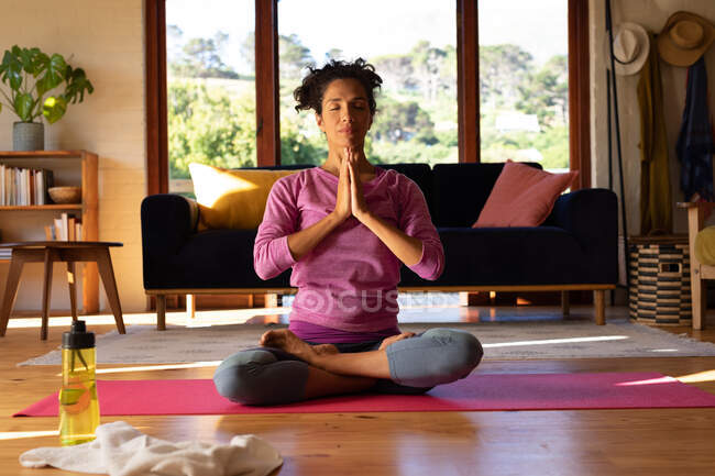Mulher branca com os olhos fechados meditando, praticando ioga em casa. Ficar em casa em auto-isolamento durante o bloqueio de quarentena. — Fotografia de Stock