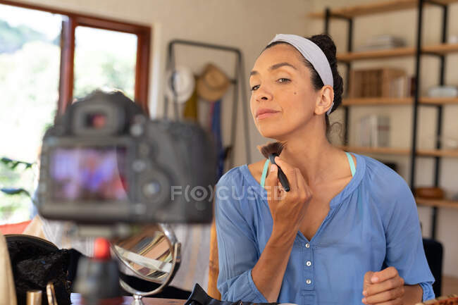 Femme blanche, vlogging, application de maquillage, à l'aide d'une brosse de maquillage à la maison. Rester à la maison en isolement personnel pendant le confinement en quarantaine. — Photo de stock