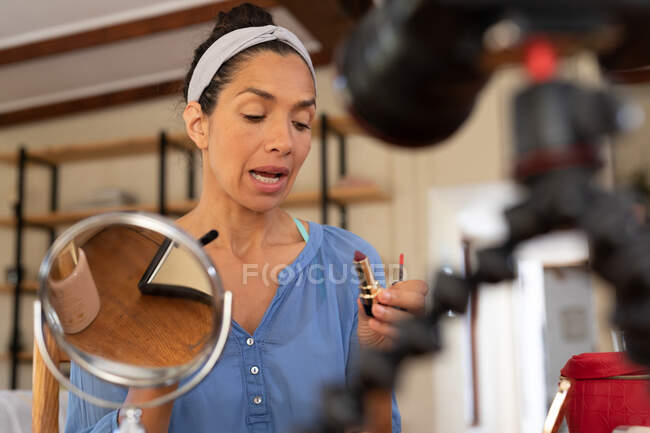 Caucasian woman, vlogging, applying makeup, holding lipstick at home. Staying at home in self isolation during quarantine lockdown. — Stock Photo