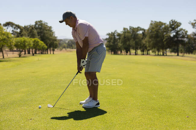 Mulher idosa caucasiana segurando clube de golfe se preparando para tiro no verde. passatempo de esportes de golfe, estilo de vida de aposentadoria saudável. — Fotografia de Stock