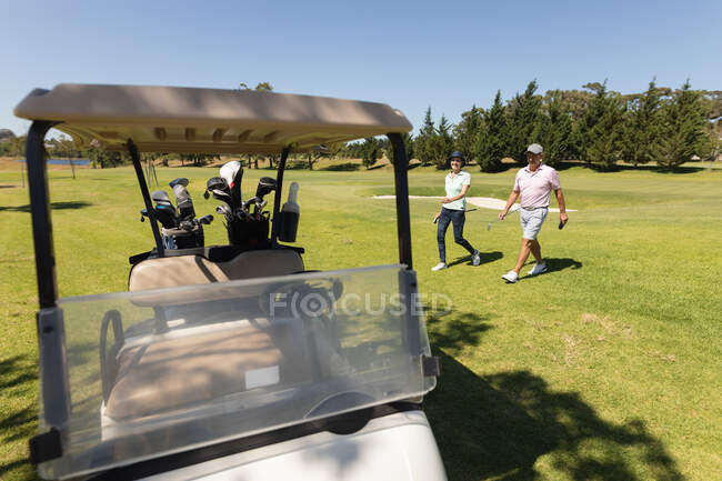 Caucasiano homem e mulher sênior saindo do saco segurando tacos de golfe. passatempo de esportes de golfe, estilo de vida de aposentadoria saudável. — Fotografia de Stock