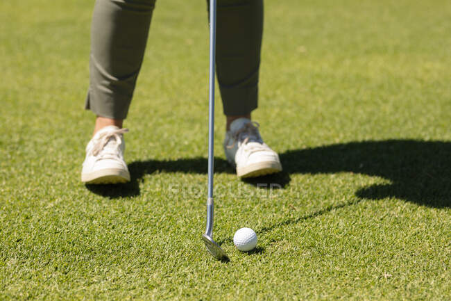 Женщина, держащая клюшку для гольфа, готовится к выстрелу на грине. гольф-спортивное хобби, здоровый пенсионный образ жизни. — стоковое фото