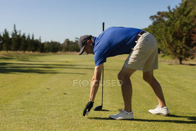 Homme âgé caucasien plaçant une balle de golf sur le vert. Golf passe-temps sportif, mode de vie sain à la retraite. — Photo de stock