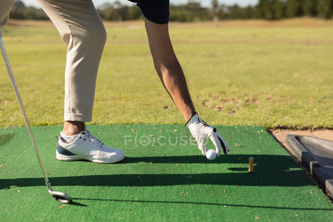 Человек кладет мяч для гольфа на зеленый. Спортивное увлечение гольфом, здоровый пенсионный образ жизни. — стоковое фото