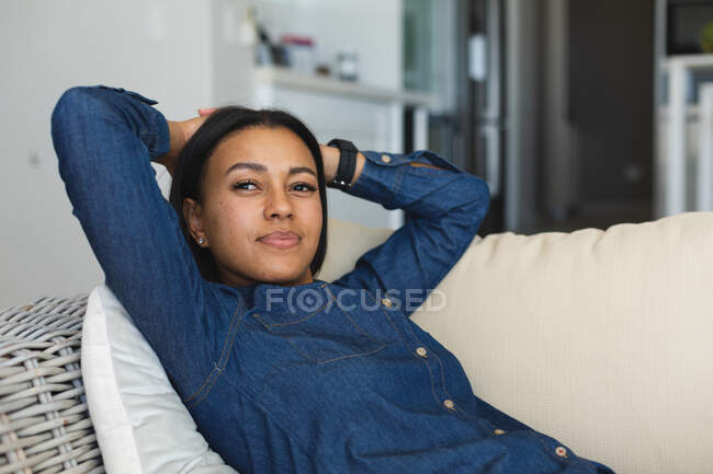Mujer afroamericana acostada en el sofá de su casa. permaneciendo en casa en aislamiento en cuarentena - foto de stock