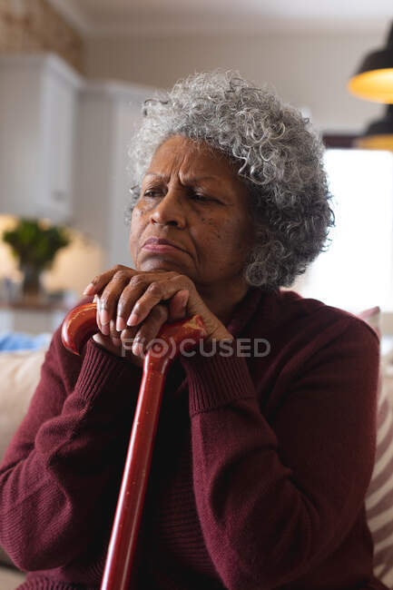 Primo piano di una donna anziana afroamericana premurosa che tiene in mano il bastone da passeggio a casa. stare a casa in isolamento personale in quarantena — Foto stock