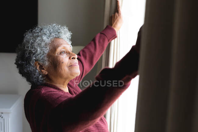 Думка африканської старшої жінки-афроамериканки відкриває вікна в себе вдома. Залишатися вдома в ізоляції в карантині. — стокове фото