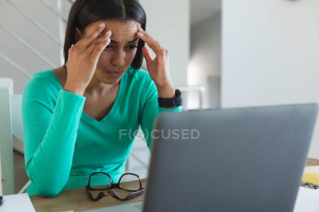Стрессовая африканская американка смотрит на экран ноутбука, работая из дома. оставаться дома в изоляции в карантинной изоляции — стоковое фото