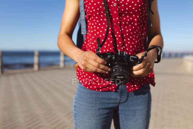 Sezione centrale della donna scattare foto sul lungomare in riva al mare. Nomade digitale in movimento lifestyle. — Foto stock