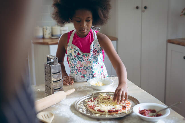 African american girl and her father making pizza together in kitchen. staying at home in self isolation during quarantine lockdown. — Stock Photo