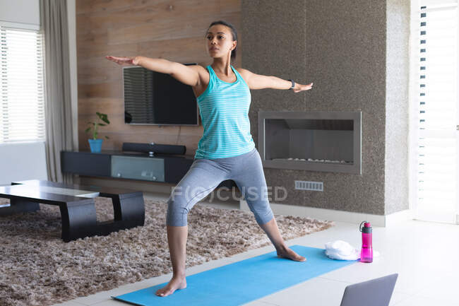Afroamerikanerin praktiziert Yoga vor dem Laptop zu Hause. Zu Hause bleiben in Selbstisolierung in Quarantäne — Stockfoto