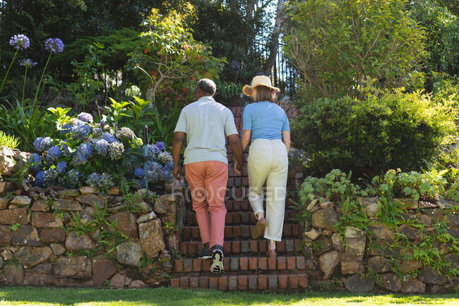 Divers couples de personnes âgées marchant dans le jardin se tenant la main. rester à la maison dans l'isolement pendant le confinement en quarantaine. — Photo de stock