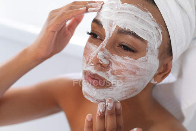 Закрийте афроамериканку маску обличчя у ванній кімнаті. Залишатися вдома в ізоляції в карантині. — стокове фото