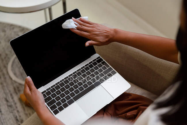 Порушення ділової жінки, що сидить, дезінфікуючи комп'ютер ноутбука. бізнесмен на роботі в сучасному офісі під час пандемії коронавірусу 19 . — стокове фото