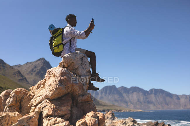 Retrato del hombre afroamericano en forma tomando fotos al aire libre. entrenamiento de fitness y estilo de vida saludable al aire libre. - foto de stock