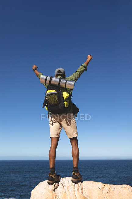 African american man exercising outdoors hiking on a mountain. fitness training and healthy outdoor lifestyle. — Stock Photo