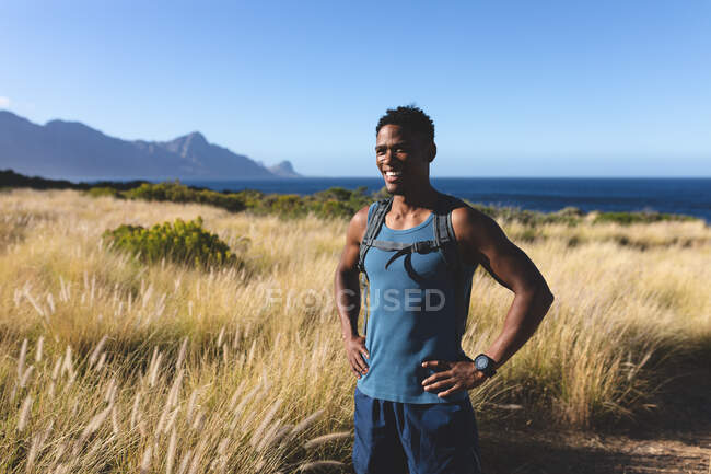Retrato del hombre afroamericano feliz en forma haciendo ejercicio al aire libre. entrenamiento de fitness y estilo de vida saludable al aire libre. - foto de stock