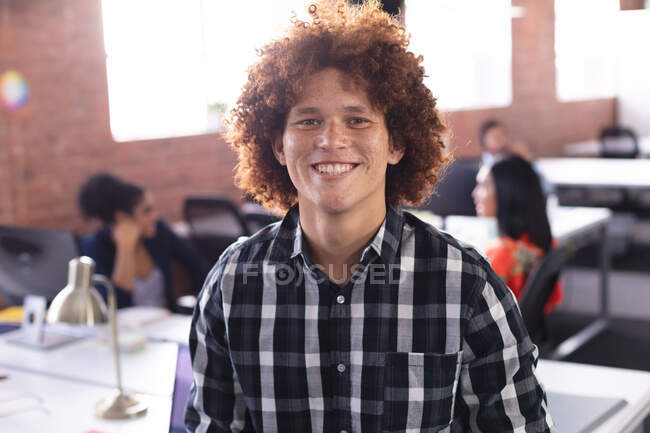 Portrait of mixed race businessman at the office looking to camera smiling. independent creative design business. — Stock Photo