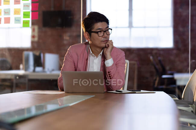 Портрет стильного азиатского бизнесмена, устроившего мозговой штурм на стеклянной стене. деловой человек за работой в современном офисе. — стоковое фото