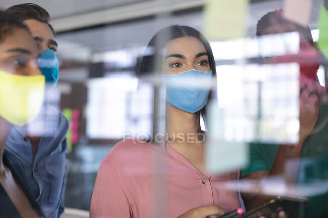 Diversi gruppi di colleghi creativi che indossano maschere facciali brainstorming in sala riunioni. business indipendente di design creativo durante covid 19 pandemia coronavirus. — Foto stock